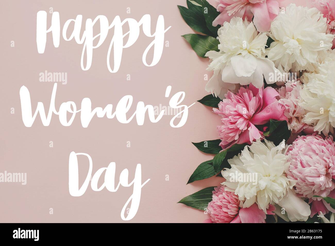 Testo Happy Women's Day. Happy Women's day lettering su elegante colore rosa peonies piatto. Biglietto di auguri floreale. Bella fiori di peonia, immagine tenera. 8 Foto Stock