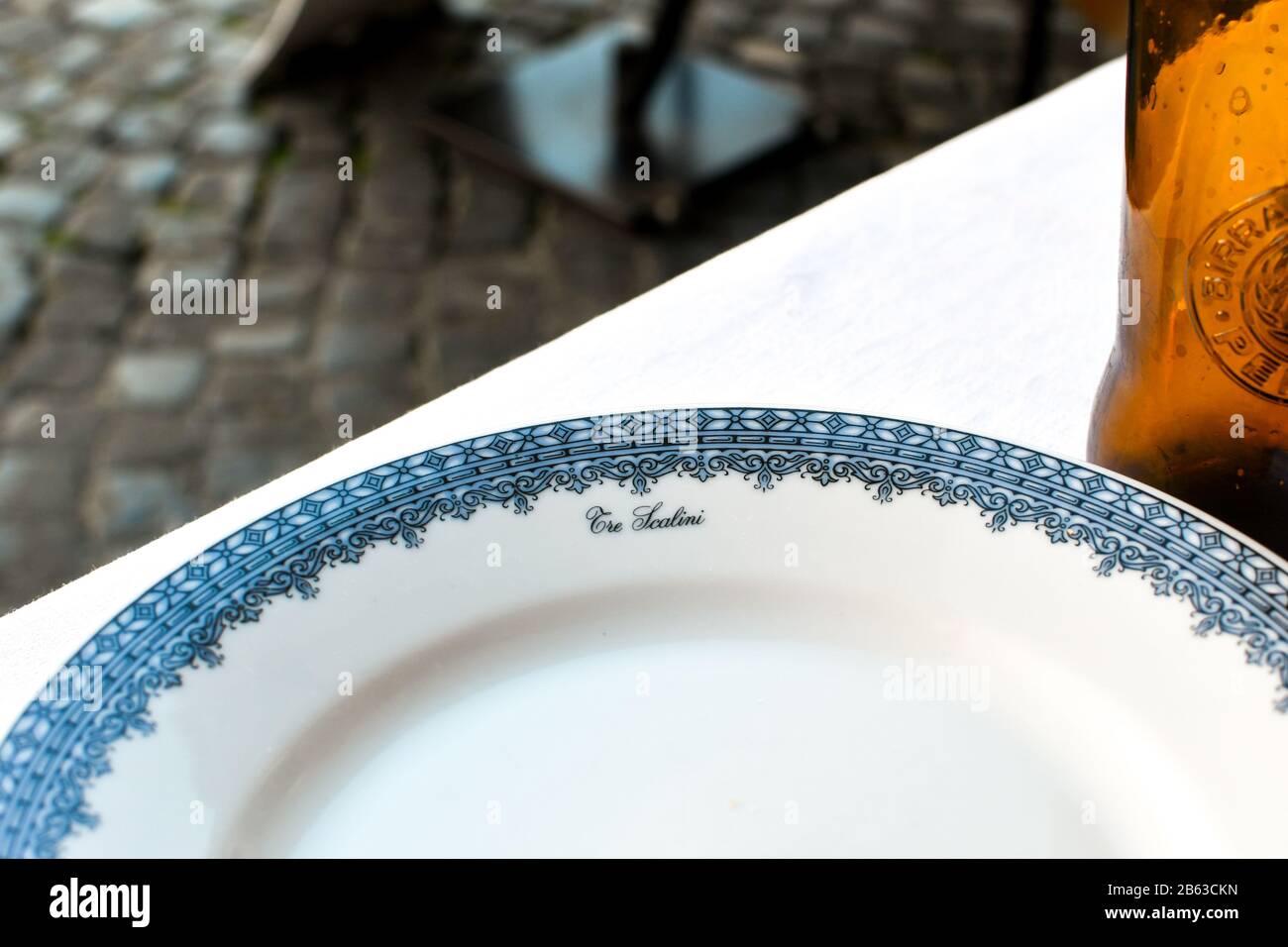 Un piatto cinese decorato da un ristorante storico di Roma Italia accanto a una bottiglia di birra, in un caffè all'aperto. Foto Stock