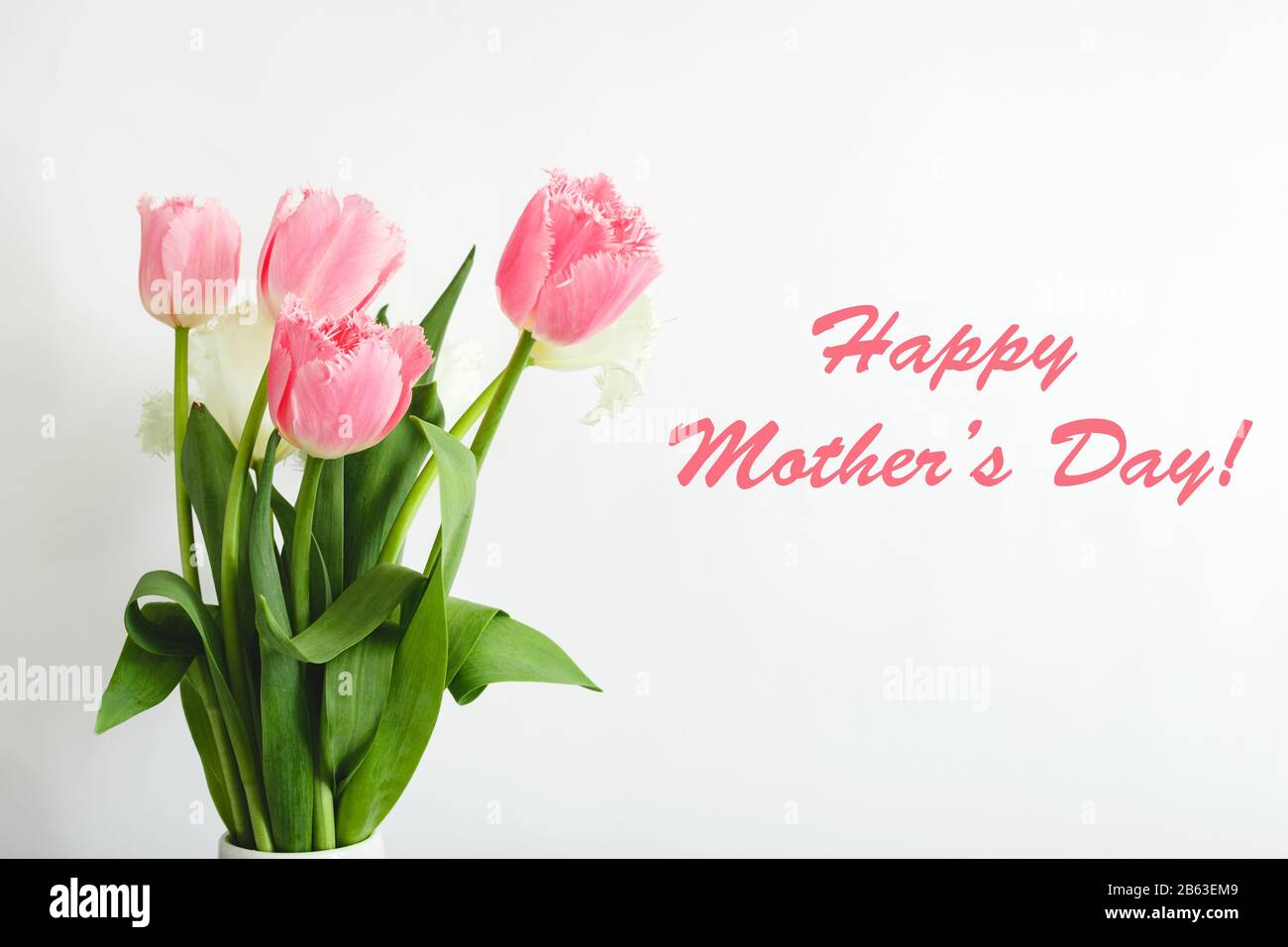 Testo Happy Mothers Day su carta regalo in bouquet di fiori su sfondo bianco. Biglietto d'auguri per mamma. Consegna fiori, carta Congratulazioni in fiori per Foto Stock