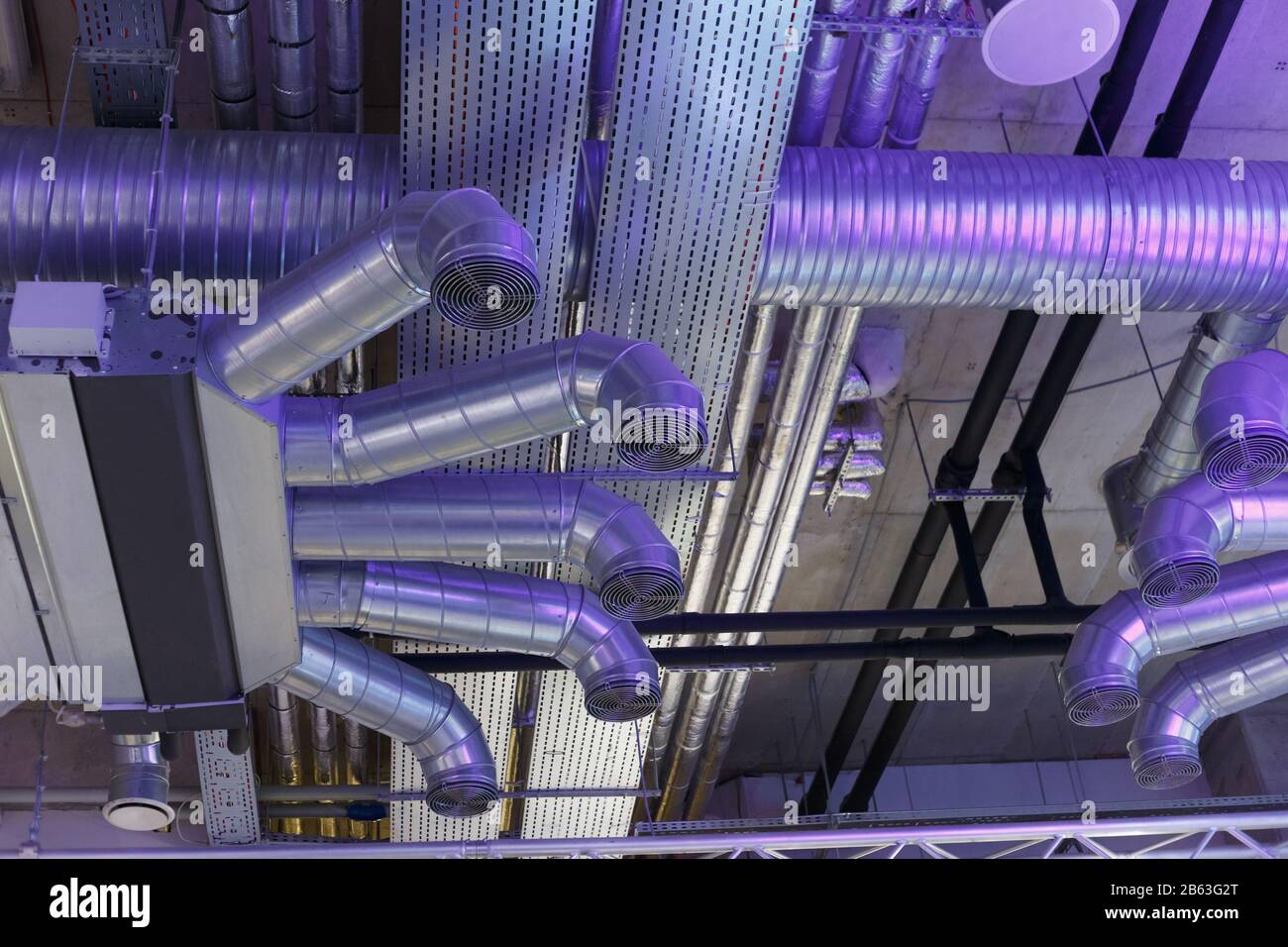 Impianti di ventilazione industriale condotti e tubazioni e comunicazioni  elettriche sotto il soffitto Foto stock - Alamy