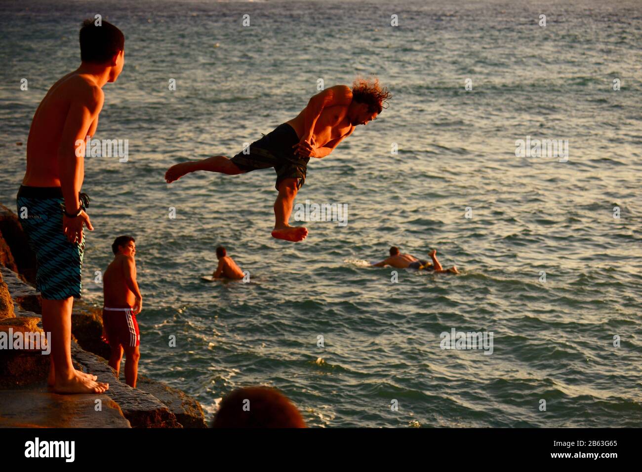 Saltatori di scogliera, indossando shorts da surf, saltando fuori dalla sporgenza nell'oceano alle Pareti della Cina sul lato est di Honolulu, isola di Oahu, Hawaii, Stati Uniti Foto Stock