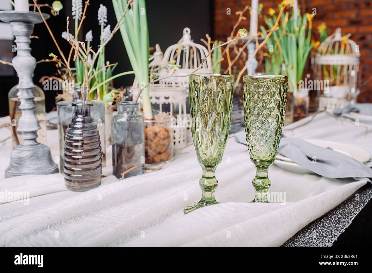 Due bicchieri di bevande verdi su un tavolo da pranzo ecologico per un romantico date.Table in un misterioso stile primaverile con piante e rami dal vivo Foto Stock