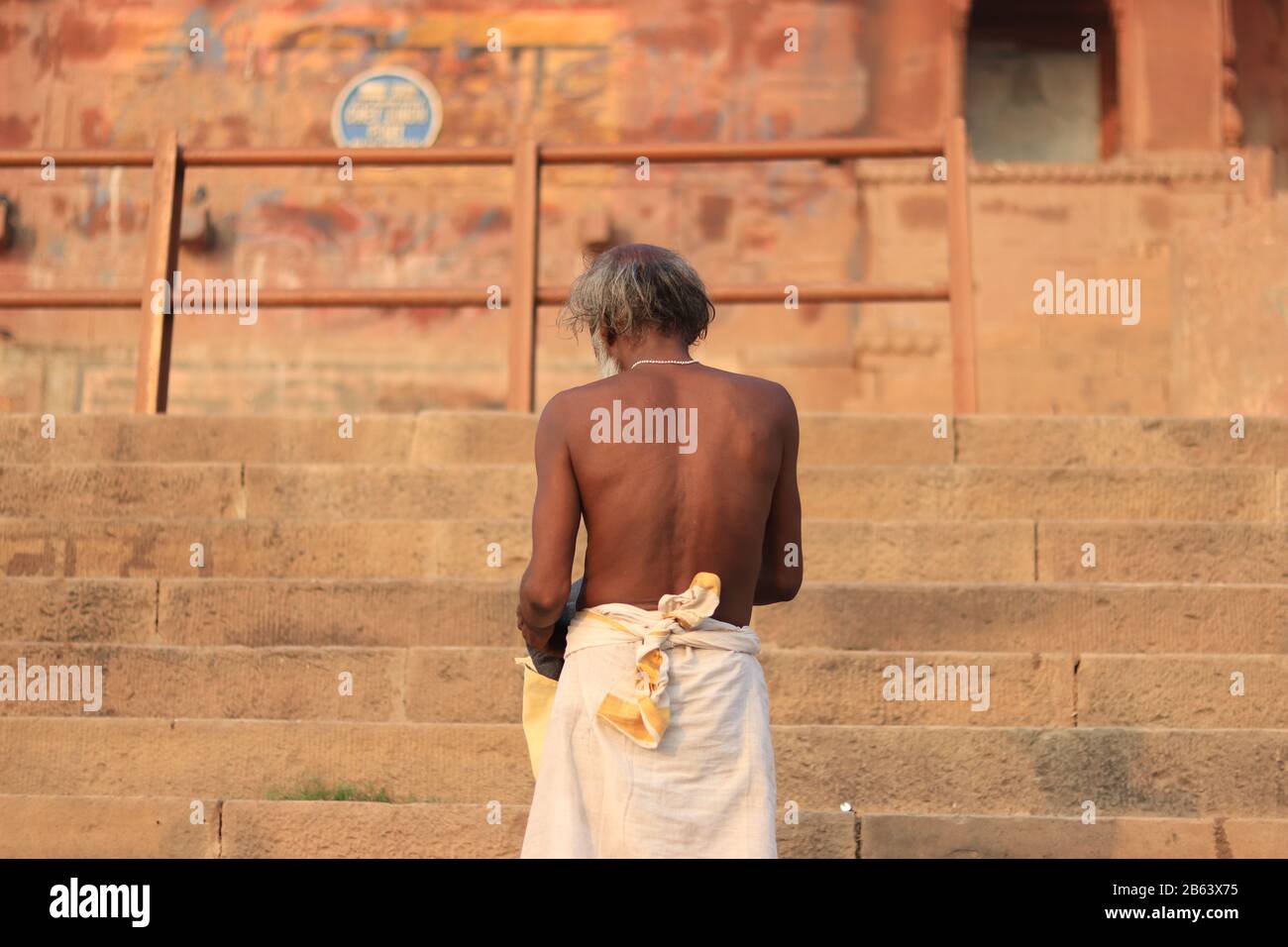 Vecchio uomo si trova di fronte al forte di Chet Singh dopo aver preso un bagno santo Foto Stock