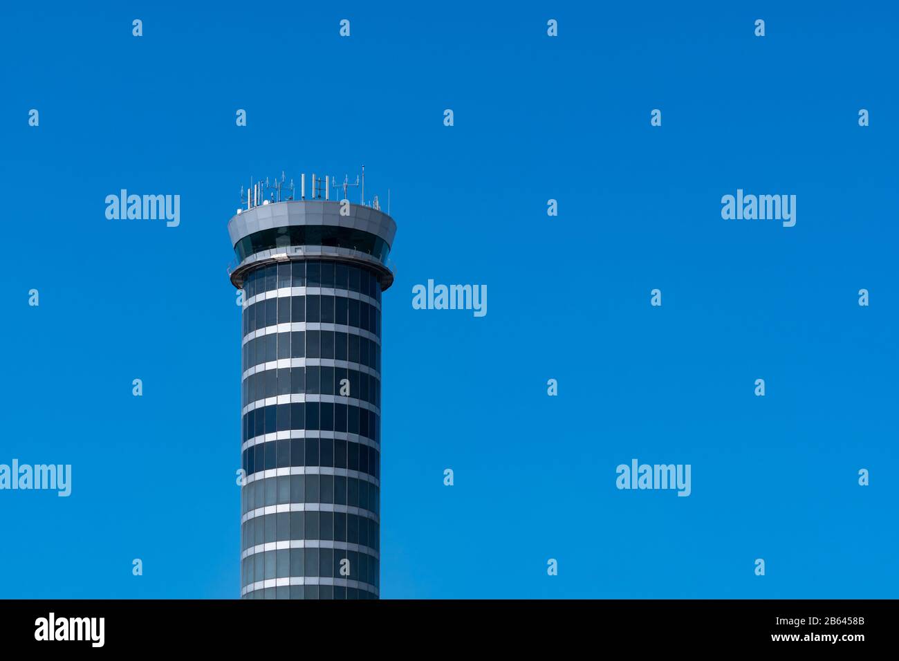 Torre di controllo del traffico aereo in aeroporto contro cielo blu chiaro. Torre di controllo del traffico aeroportuale per controllare lo spazio aereo tramite radar. Tecnologia aeronautica. Foto Stock