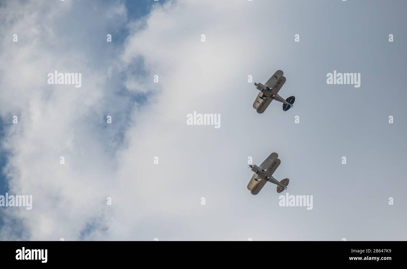 Alberton, Sudafrica - due biplani sponsorizzati Goodyear volano sotto la copertura della nube in un'immagine di esercitazione di volo di formazione con lo spazio della copia Foto Stock