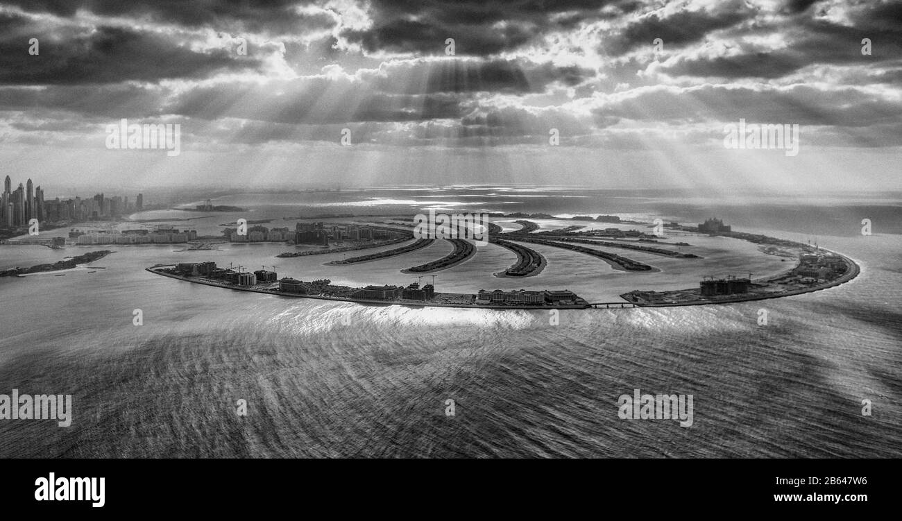 Dubai, Emirati Arabi Uniti. Le forme geometriche di Palm Jumeirah dall'elicottero al tramonto con le nuvole. Foto Stock