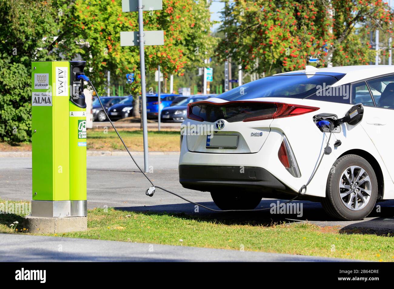Il bianco Toyota Prius Plug-in Hybrid o PHV collegato alla stazione di ricarica per strada a Seinäjoki, Finlandia. 10 Agosto 2019. Foto Stock