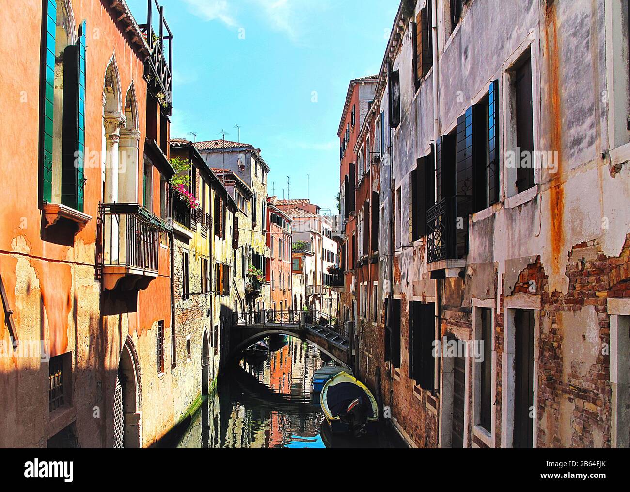 Pareti di mattoni rossi di colore arancio della stretta via dei canali, Venezia Italia Foto Stock