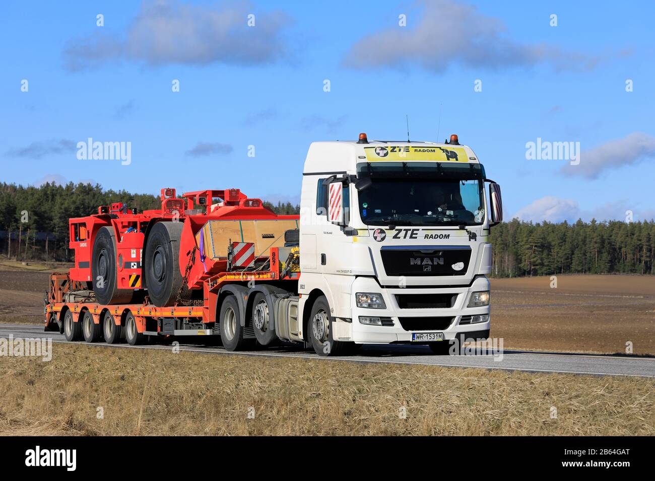 White MAN TGX 26.440 camion di ZTE Radom trasporta la pala sotterranea Sandvik per operazioni minerarie nella giornata di sole della primavera. Salo, Finlandia. Mar 6, 20. Foto Stock