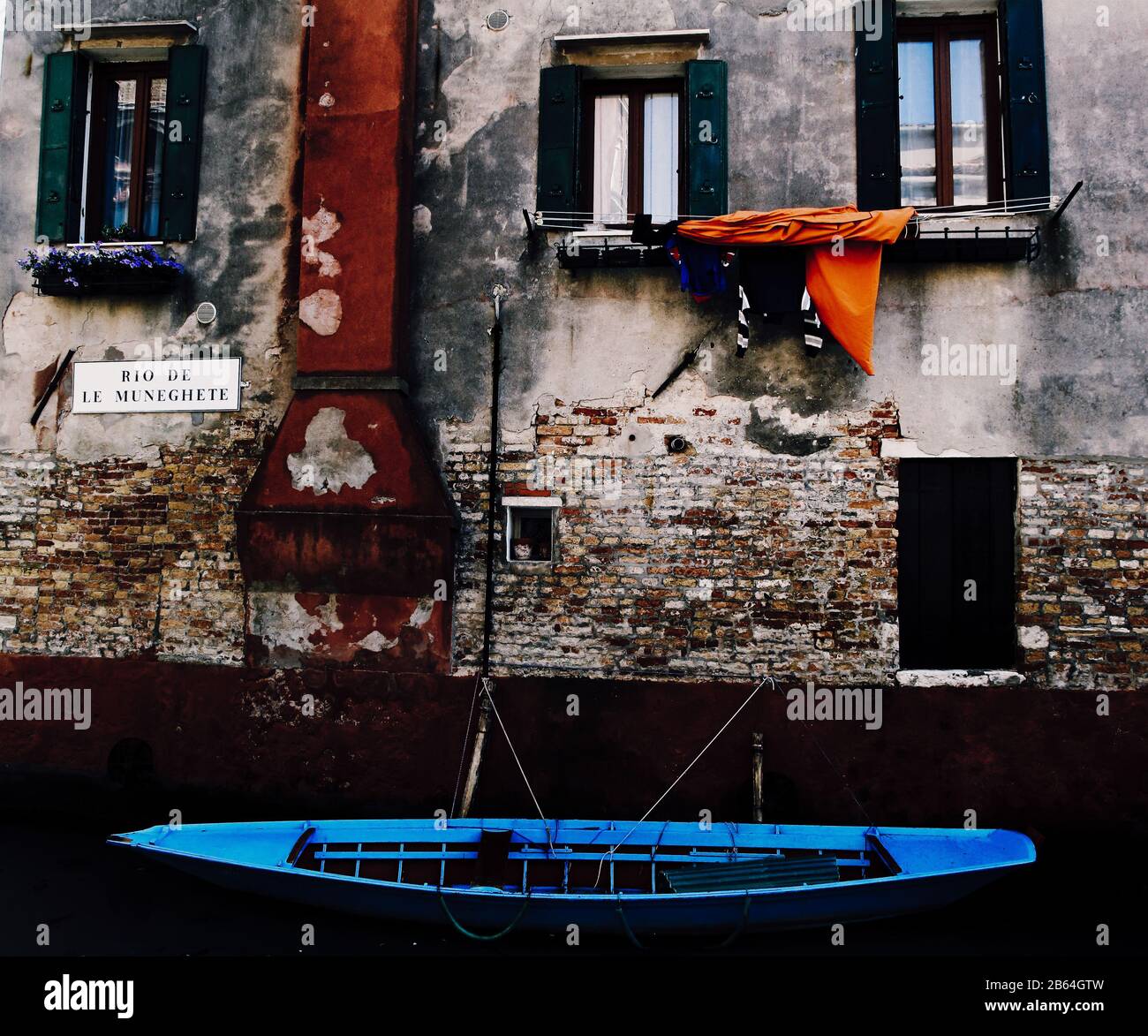 Barca blu ormeggiata a costruzione a Venezia, Italia Foto Stock