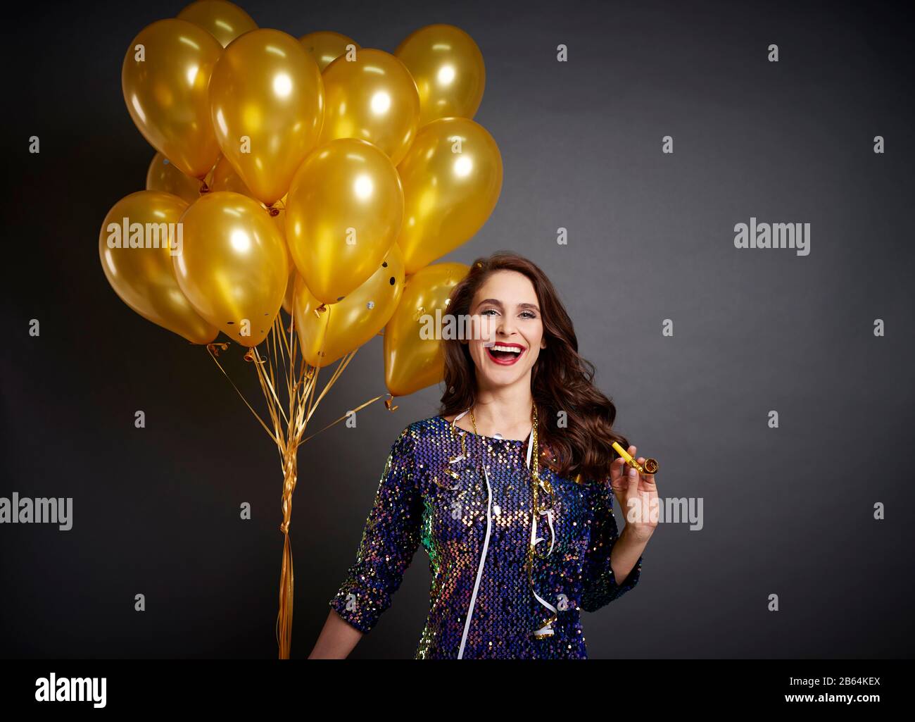 Bella donna con palloncini d'oro in studio girato Foto Stock