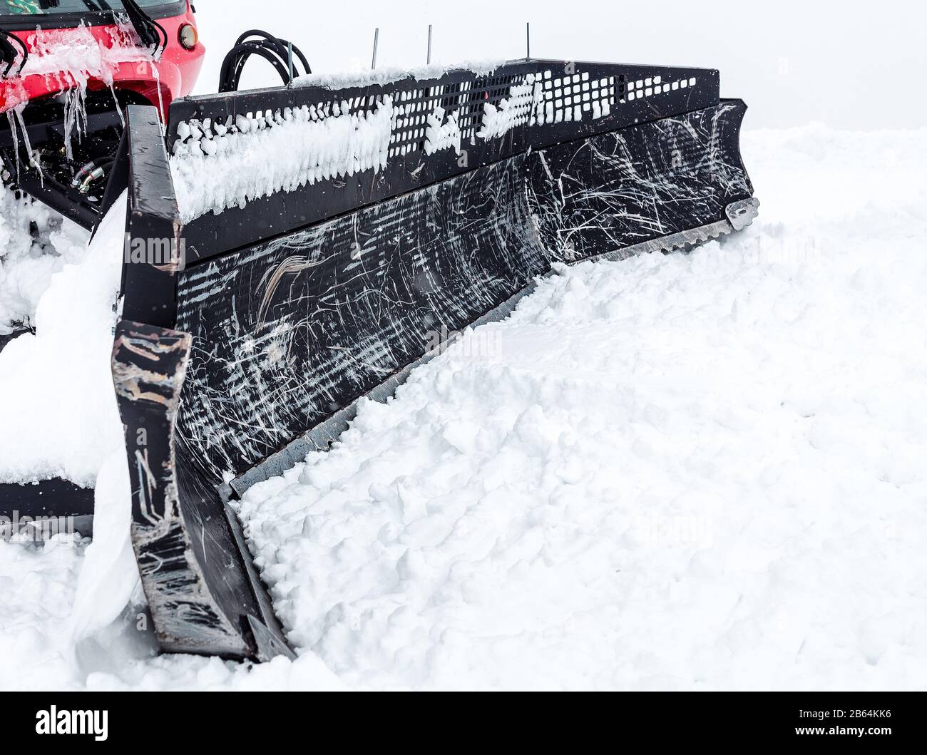 Gatto delle nevi che sgombrano la strada con la benna dalla neve Foto Stock