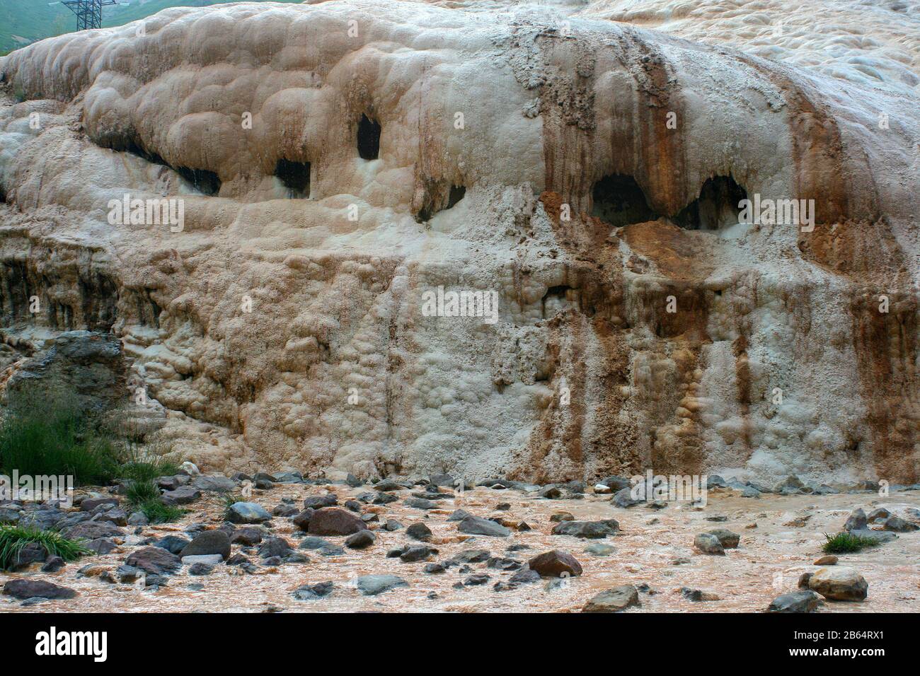 Il torrente di acqua minerale copriva il pendio con depositi di travertino, Cross Pass, Gudauri, Georgia Foto Stock