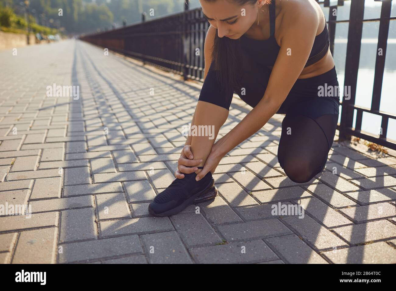 Infortunio al ginocchio in atleta ragazza nel parco. Foto Stock