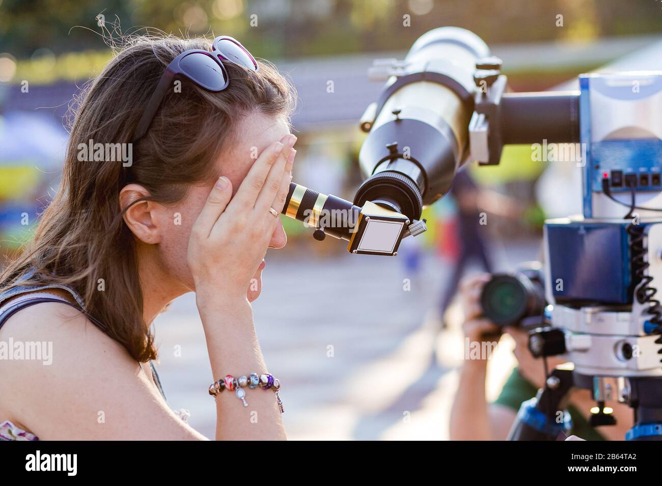 Giovane donna che guarda attraverso il telescopio solare Foto Stock