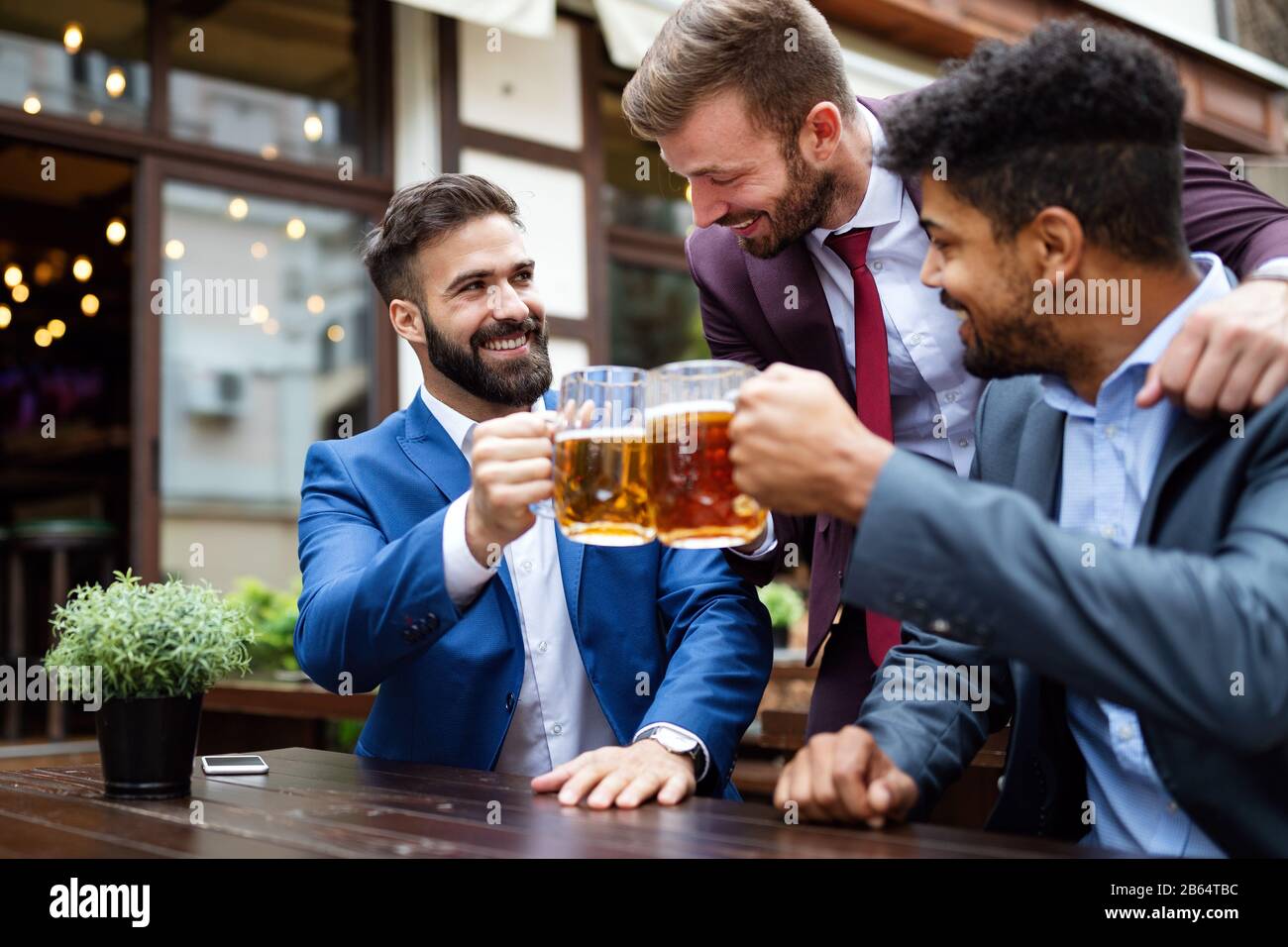 Persone, uomini, tempo libero, amicizia e celebrazione concetto. Amici maschi felici che bevono birra al pub Foto Stock
