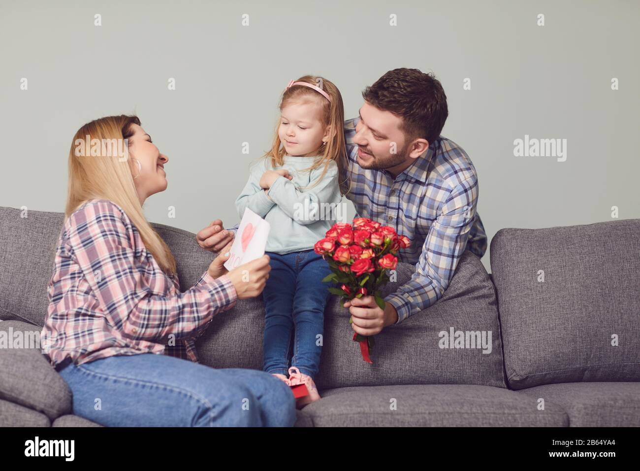 Buon giorno della madre. I bambini e il padre si congratulano con la mamma con i fiori dono Foto Stock