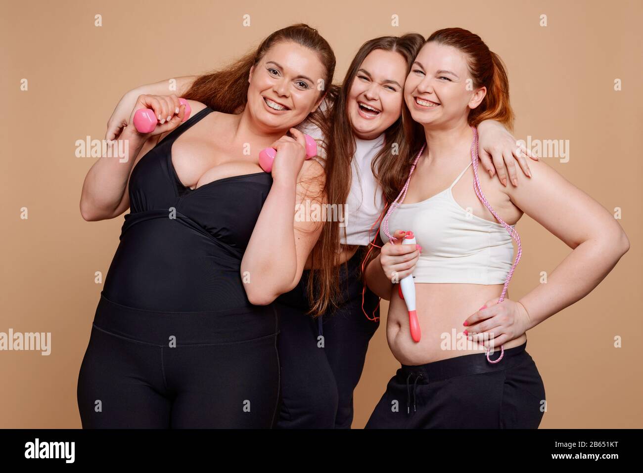 Più ragazze di dimensione che posano su sfondo beige dopo le lezioni di idoneità Foto Stock