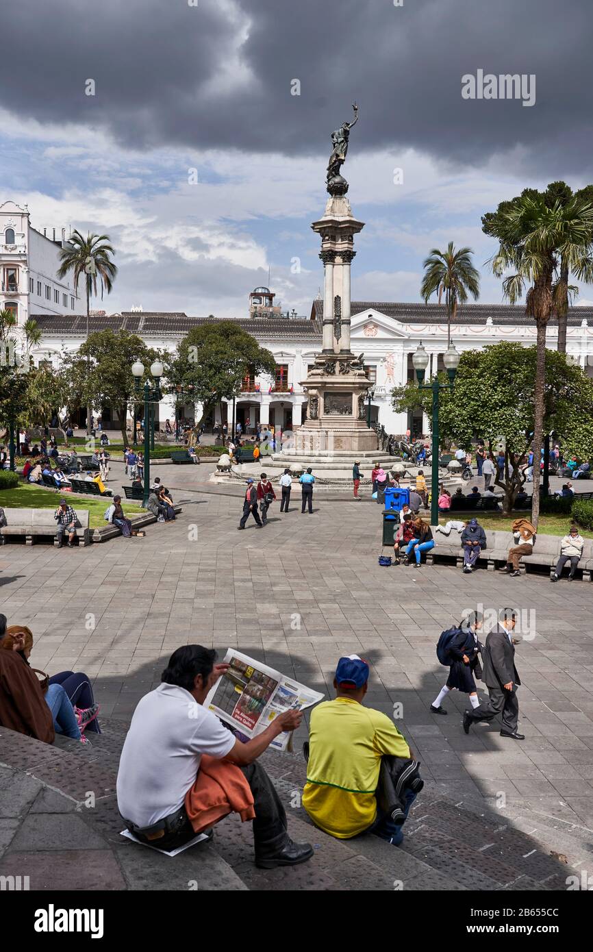 Uomo che legge carta sui gradini in Plaza de la Independencia, Quito, Ecuador Foto Stock