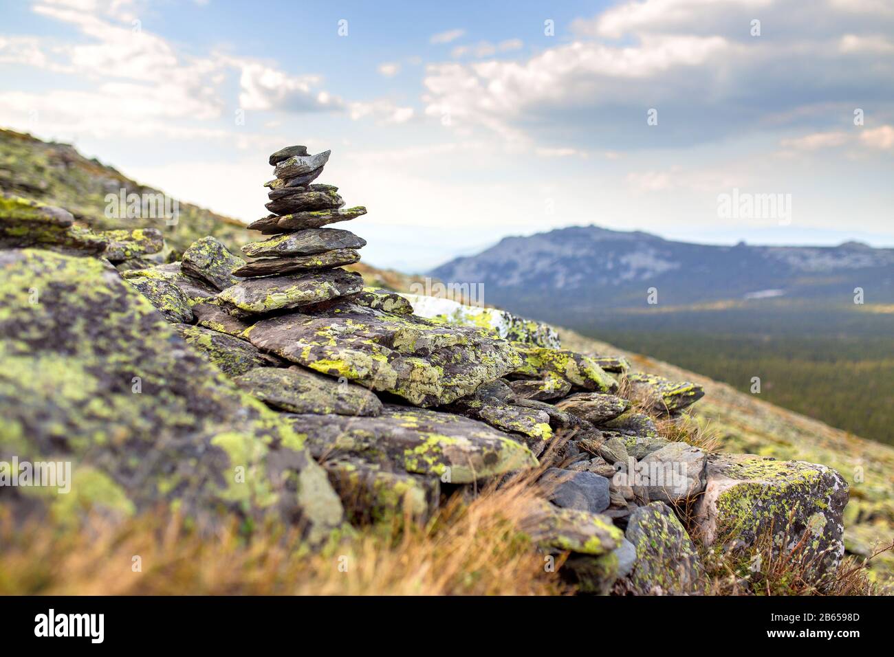 Granito cairn pietra come un segno di navigazione sulla cima della montagna Foto Stock