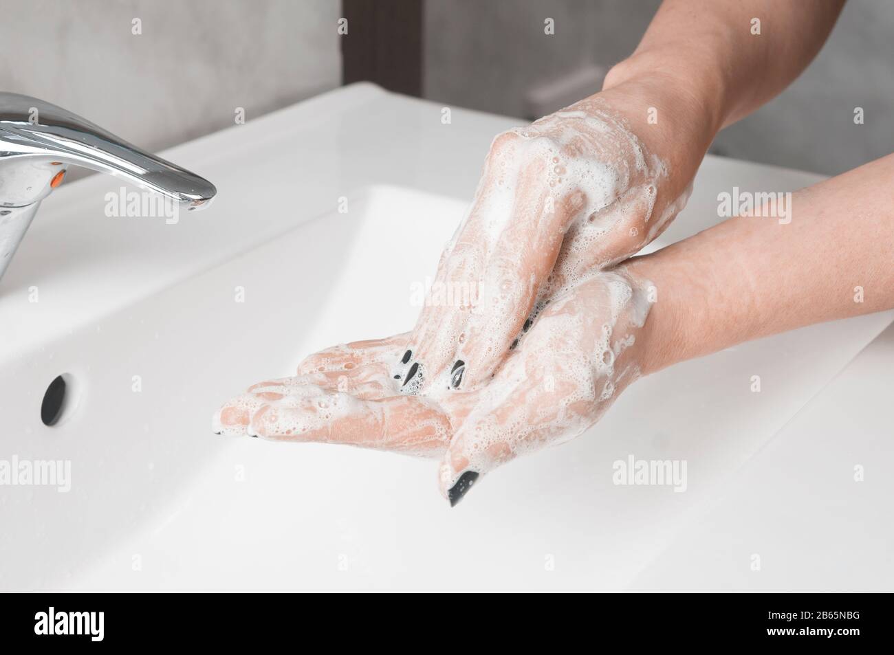 Tecniche di lavaggio delle mani: Donna strofinare il palmo della mano con le dita dell'altra mano Foto Stock