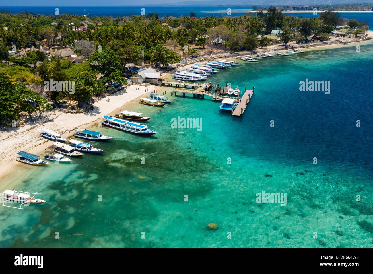 Veduta aerea delle barche ormeggiate da una bellissima barriera corallina tropicale e spiaggia su una piccola isola (Gili Air, Indonesia) Foto Stock