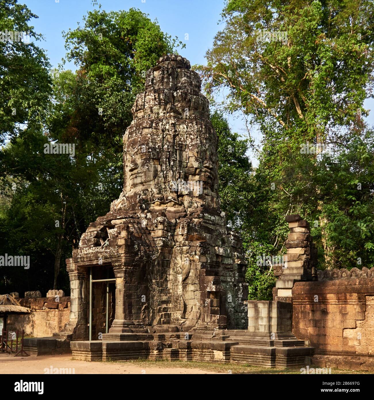 Sito archeologico, la porta sud di Angkor Thom conduce al Tempio di Bayon. La città di Angkor Thom, Cambogia è stata costruita nel tardo 12 ° / inizio 13 ° secolo dal re buddista Mahayana Jayavarman VII. È piena di questi enigmatici volti, spesso di fronte in tutte e quattro le direzioni cardinali. Sono questi il volto del re-Dio o del Buddha? Foto Stock