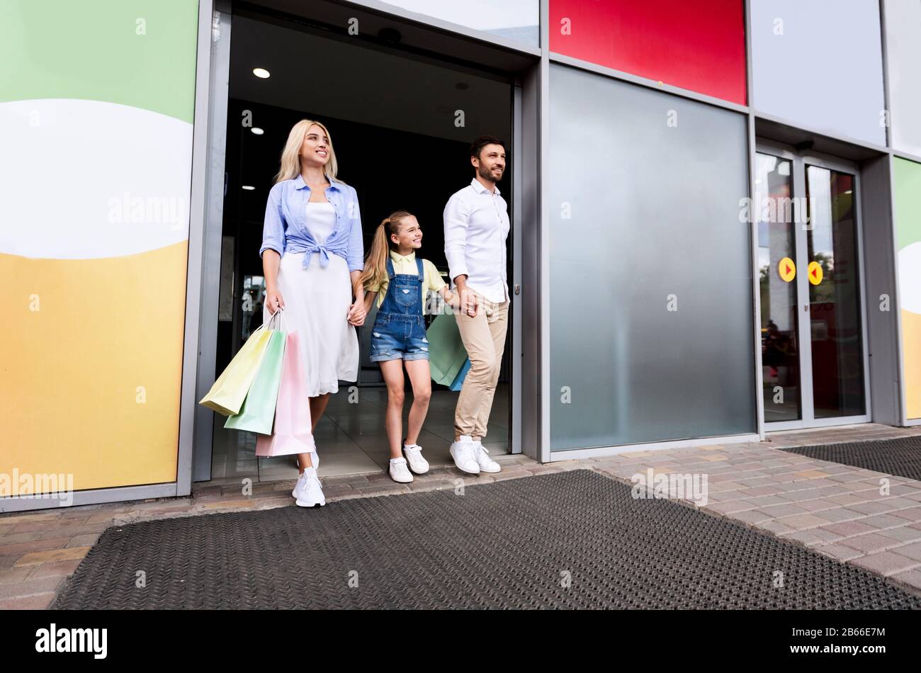 Famiglia Dopo Successo Shopping Holding Shopper Bags Lasciando Mall Foto Stock