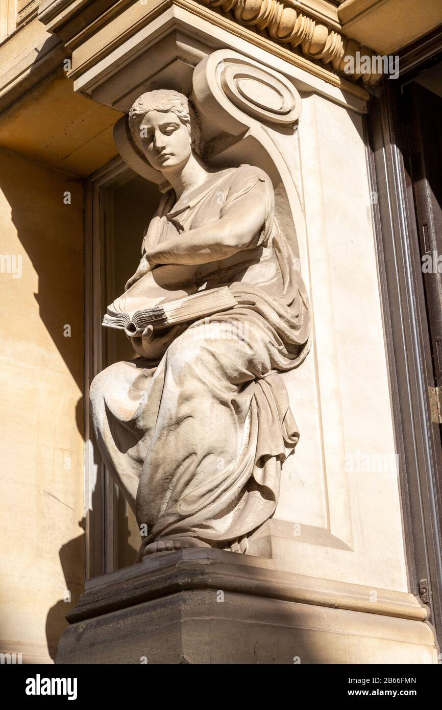 Scultura vittoriana di donna che legge un libro fuori vecchio edificio biblioteca nel centro della città, Cardiff, Galles del Sud, Regno Unito Foto Stock