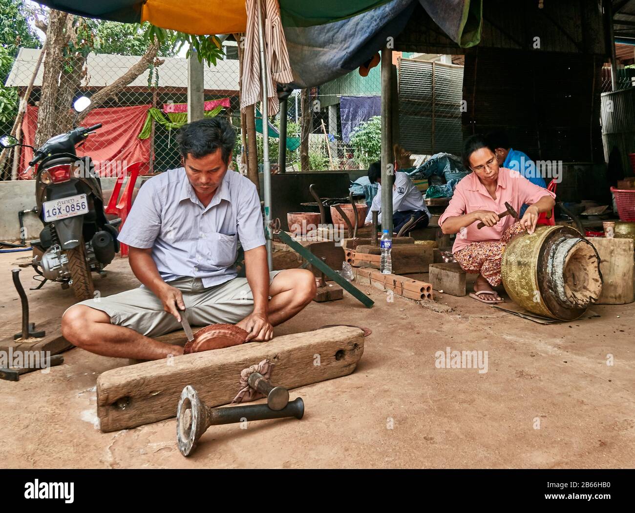 Cambogia, Siam Reap. Artigiano al lavoro nel villaggio di Koh Chen specializzato in rame calderone, per creare un bel design Foto Stock