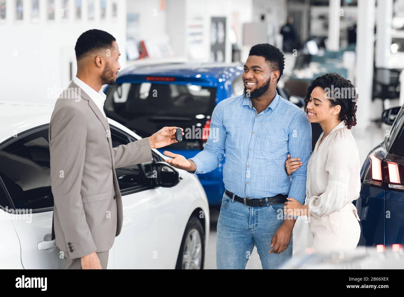 Afro Coppia Che Prende La Chiave Dal Responsabile Nell'Ufficio Di Noleggio Dell'Automobile Foto Stock