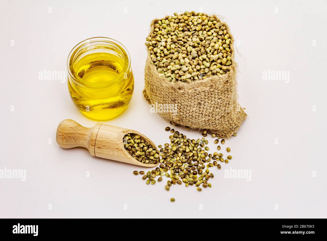 Semi di canapa maturi in sacco e olio di canapa isolato su sfondo bianco. Trend cibo, medicina e ingrediente di bellezza, sano stile di vita concetto Foto Stock