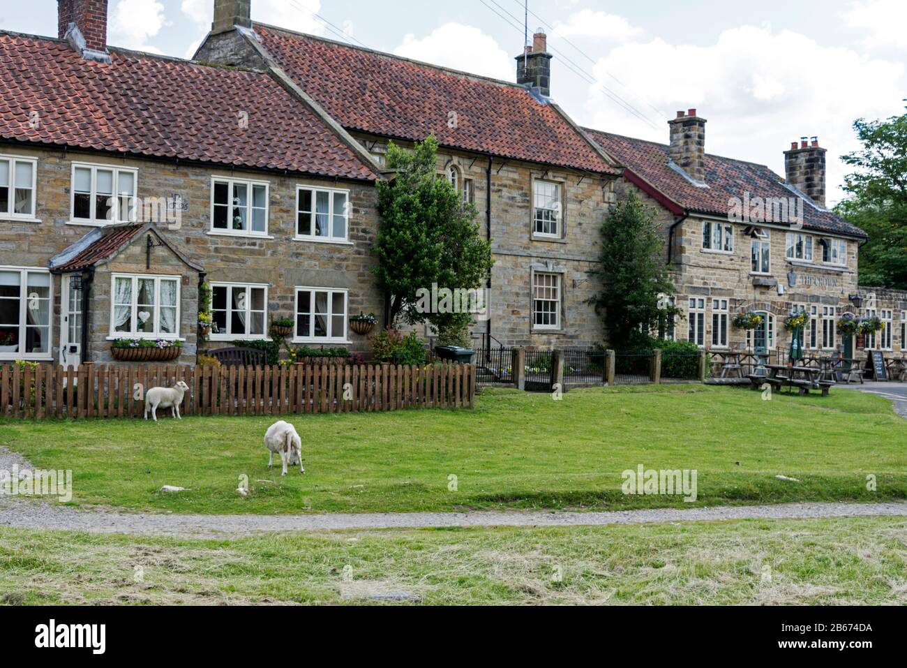 Hutton-le-Hole è un piccolo villaggio tradizionale in pietra dello Yorkshire con pecore da pascolo che si spostano liberamente. Il villaggio è popolare tra i turisti a North York Foto Stock