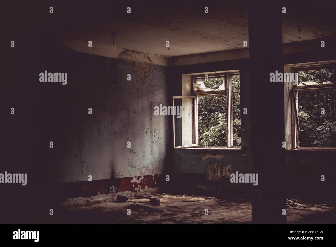 Defocus horror halloween sfondo. Camera oscura in un edificio abbandonato in rovina. Luce da una finestra con vetro rotto. Foto Stock