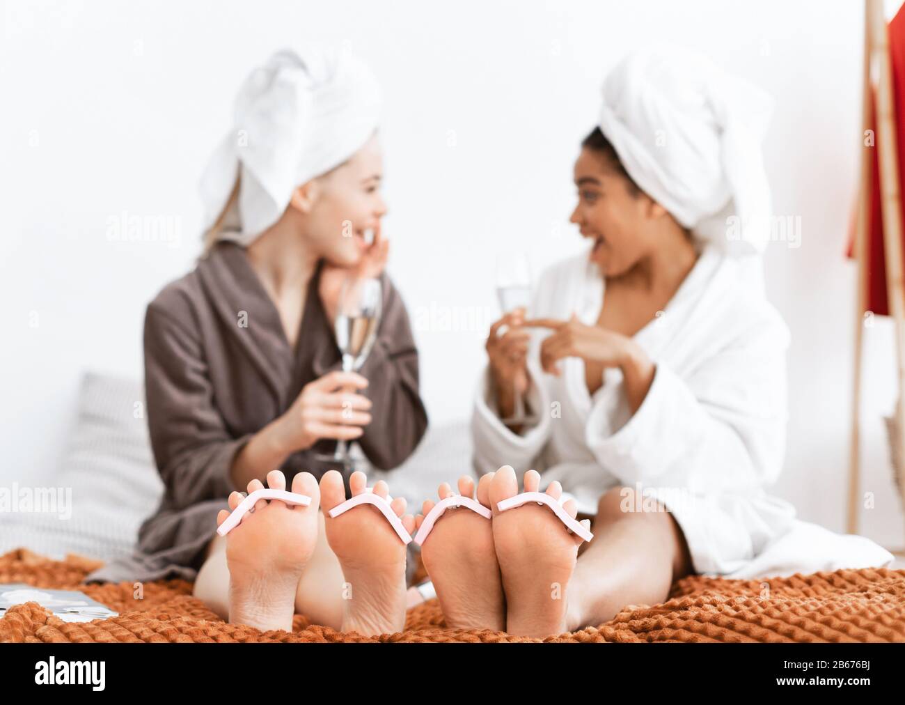 Girlfriends fare pedicure e bere champagne a casa Foto Stock