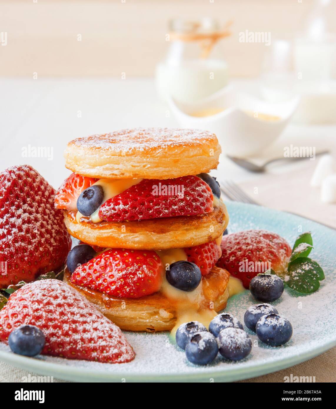 Mille Feuille, dischi di pasta sfoglia con fragole giganti e mirtilli con limone cagliata. Ricetta di Gordon Ramsay. Delizioso dessert francese con estate b Foto Stock