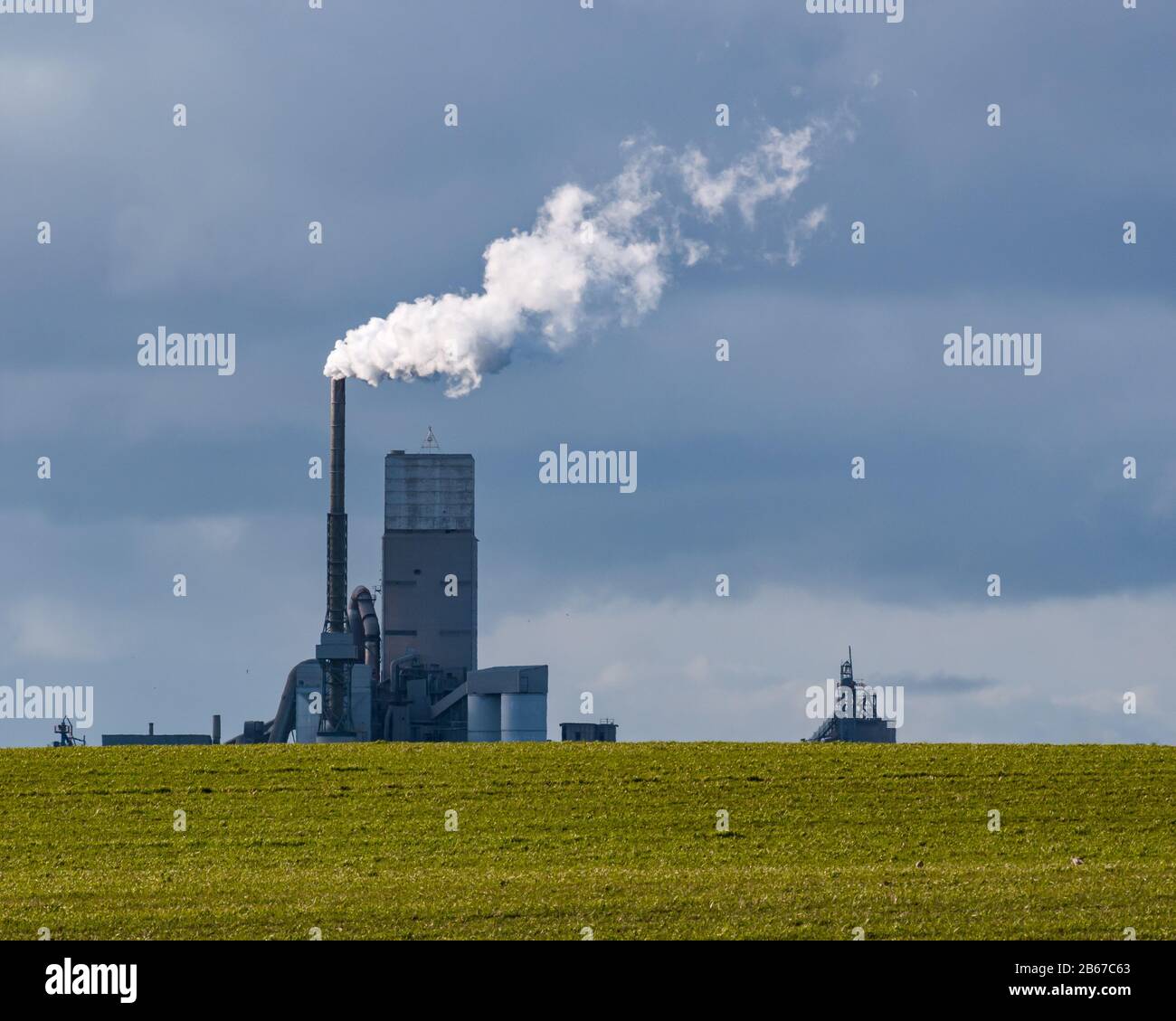 Vapore che fuoriesce dalla torre di raffreddamento della fabbrica di cemento con cielo tempestoso, Dunbar, East Lothian, Scozia, Regno Unito Foto Stock