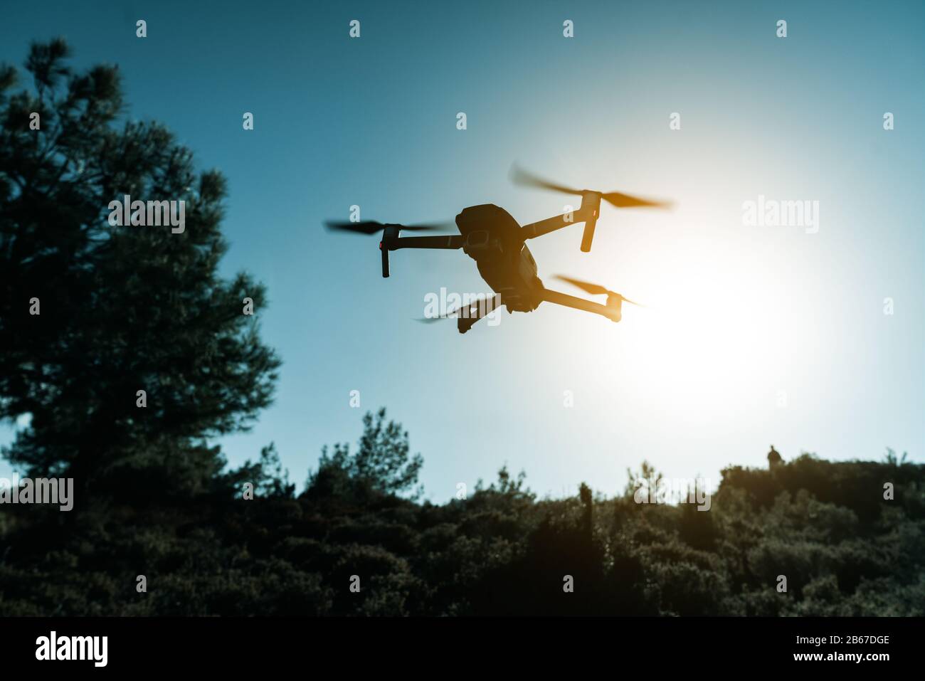 Una silhouette di un drone Quadrocopter con la fotocamera contro il cielo blu Foto Stock