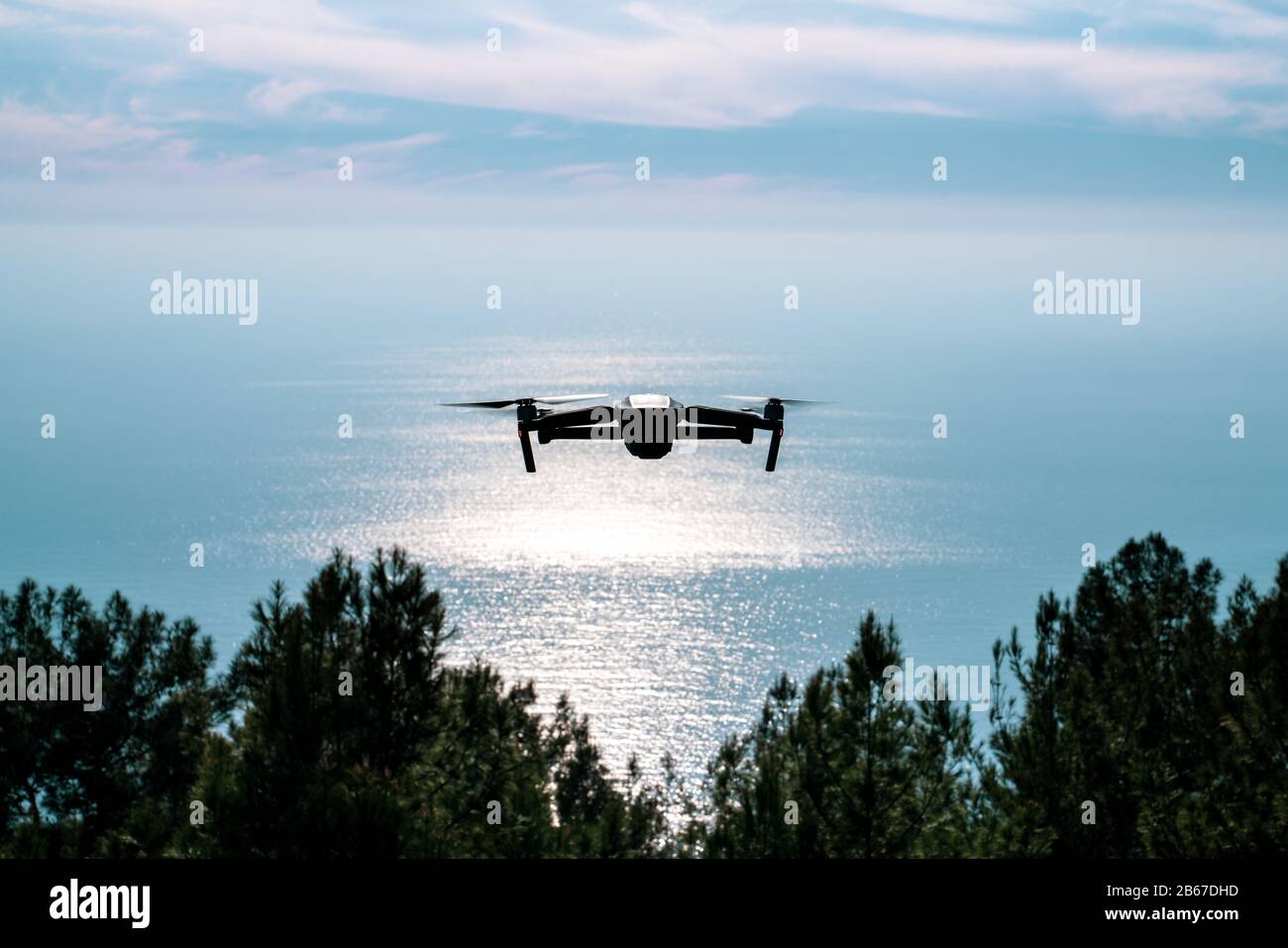 Una silhouette di un drone Quadrocopter con la fotocamera contro il cielo blu Foto Stock
