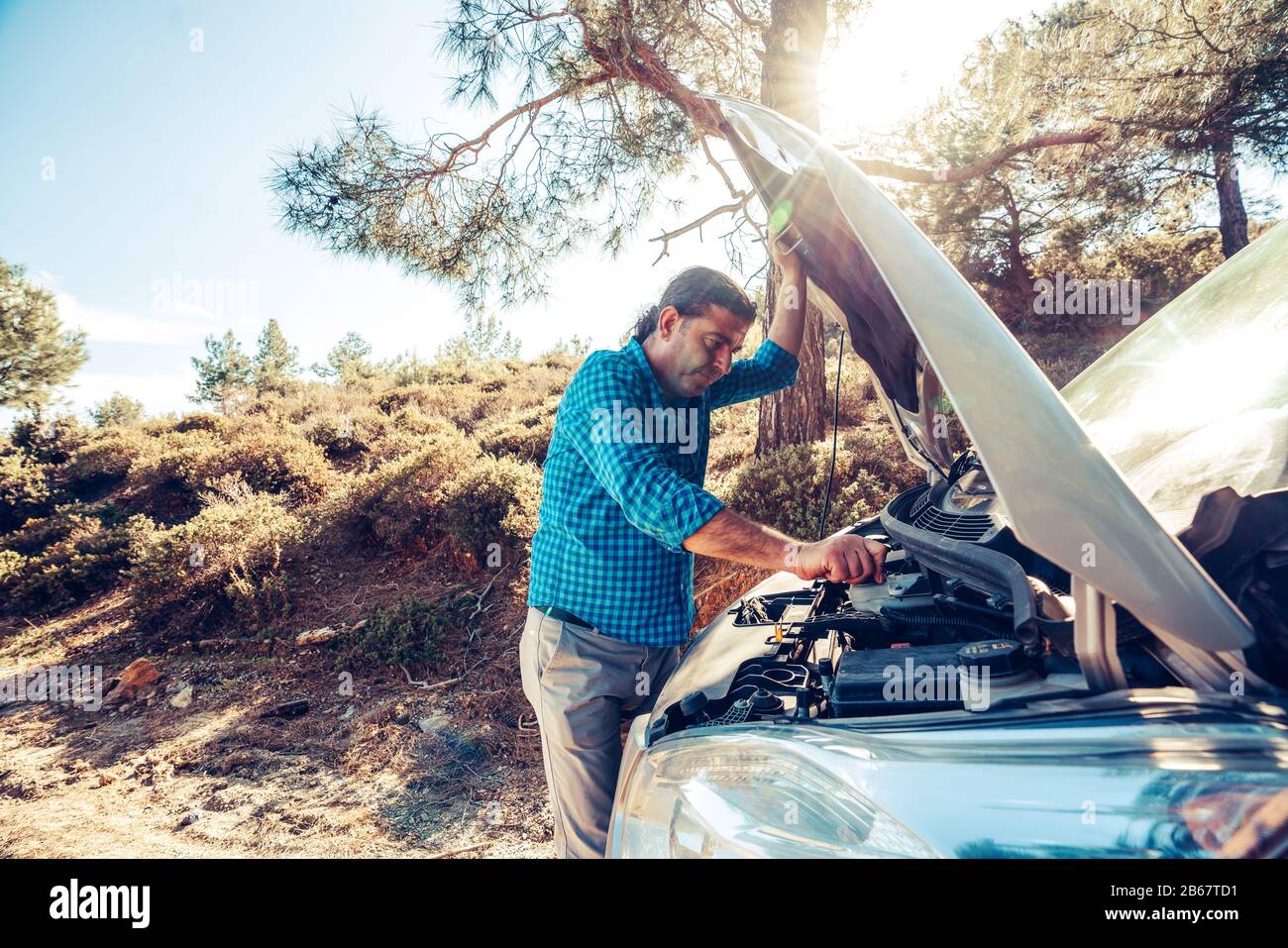 L'uomo sta cercando di aprire il cofano per auto per problemi di auto. Concetto di trasporto e veicolo Foto Stock