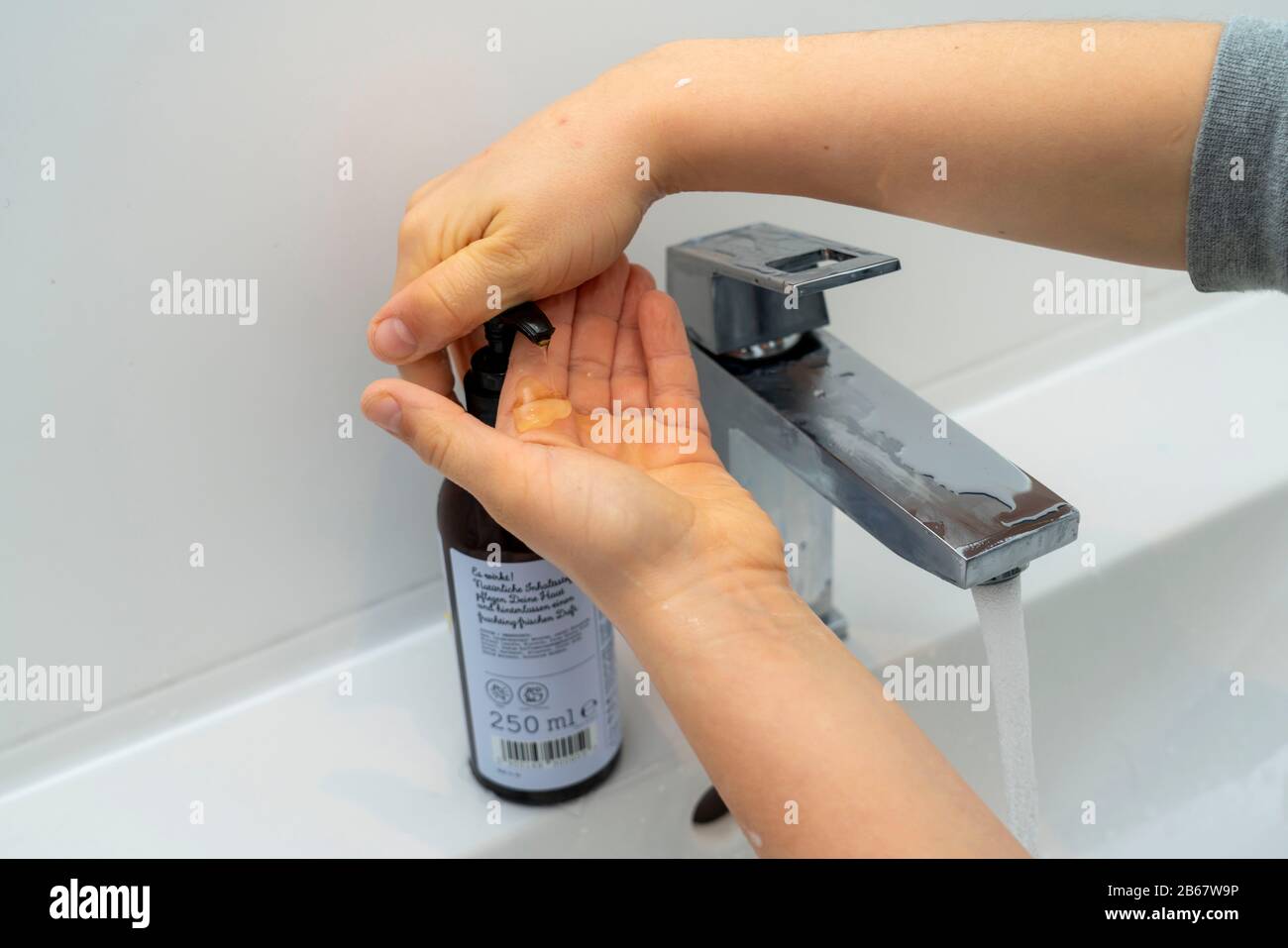 Igiene domestica, lavarsi le mani con sapone liquido, ragazzo di 9 anni, Foto Stock