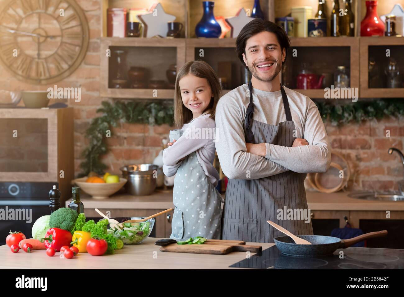Padre E Figlia In Grembiuli Che Posano In Cucina, Cucina Alimentare Insieme Foto Stock