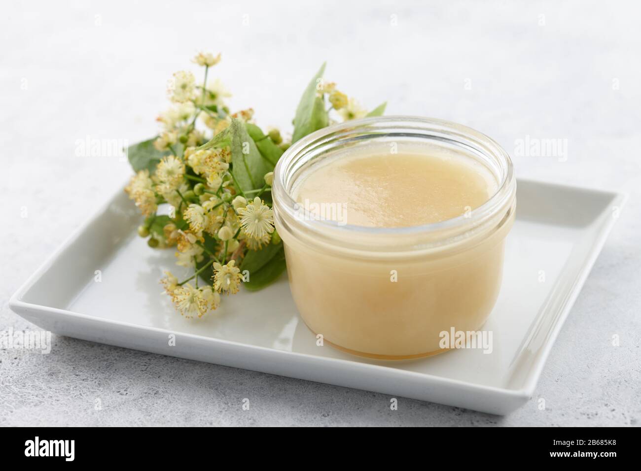 Vaso di miele con fiori di tiglio da vicino Foto Stock