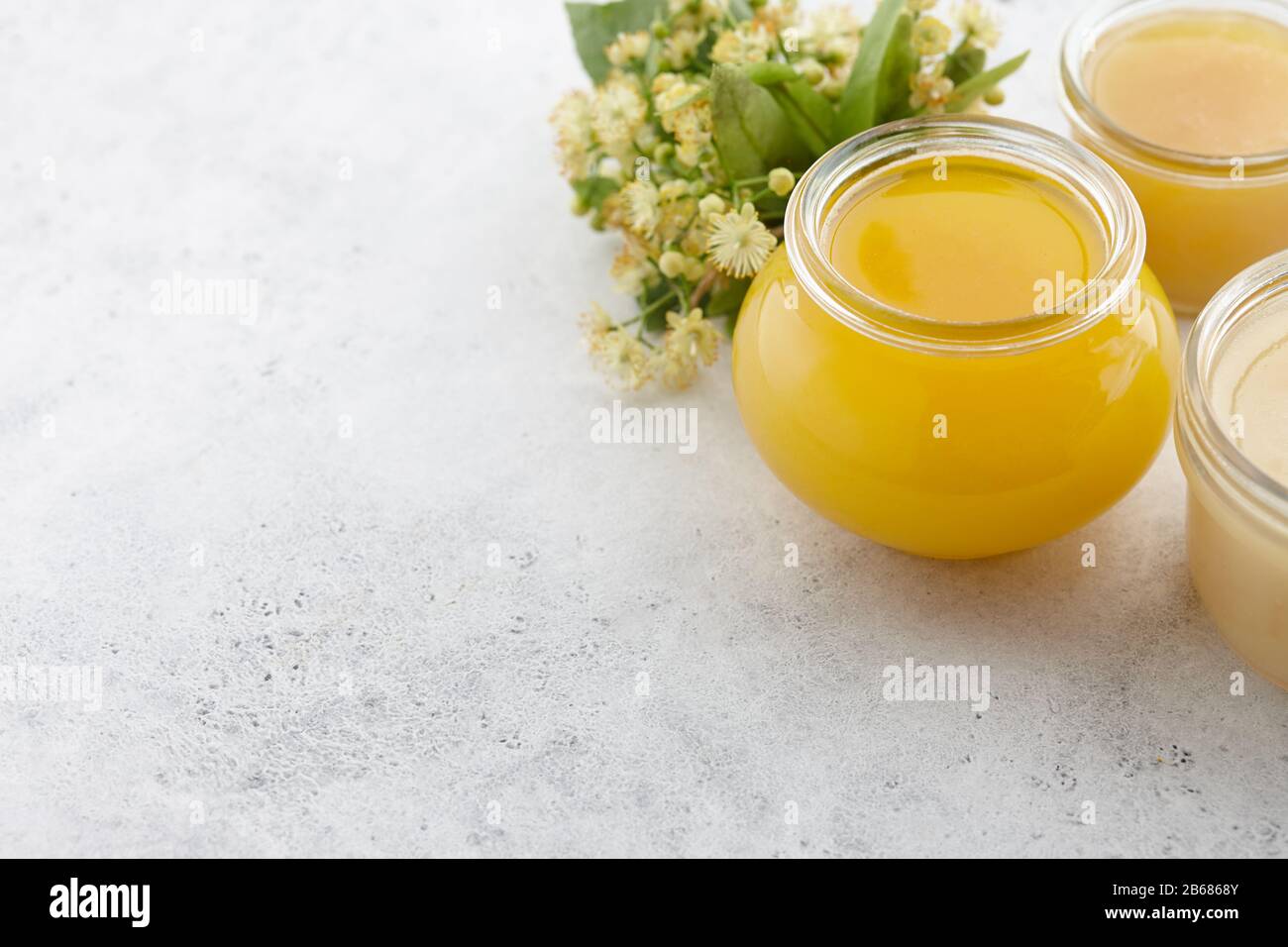 Vaso di miele con fiori di tiglio da vicino Foto Stock