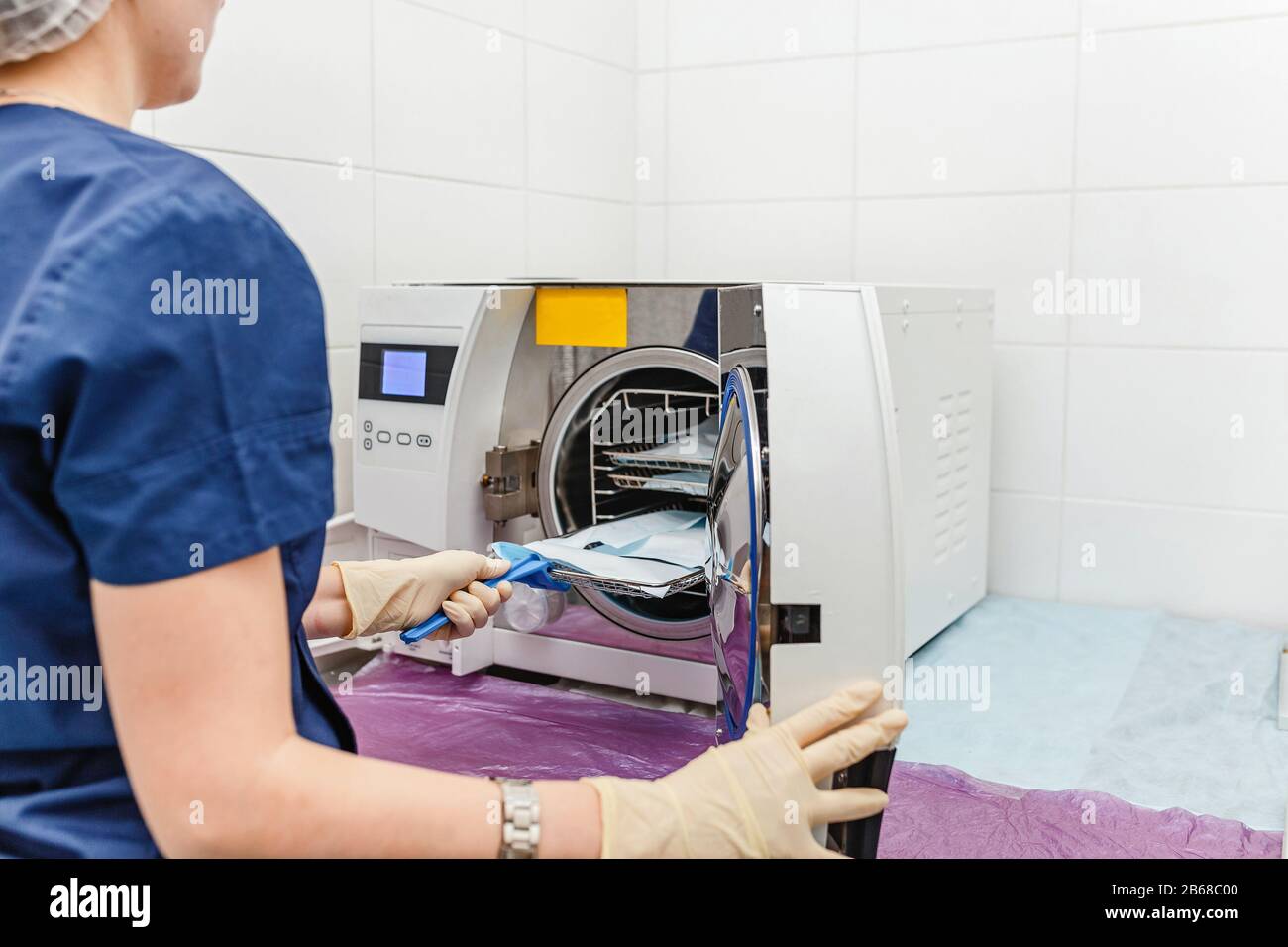 Il giovane medico mette in autoclave medica per la sterilizzazione di strumenti  chirurgici e dentali Foto stock - Alamy