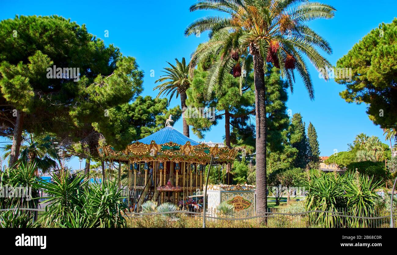 Nizza, Francia - 4 Ottobre 2018: Vista a un parco con una giostra storica sotto le palme a Nizza. Foto Stock