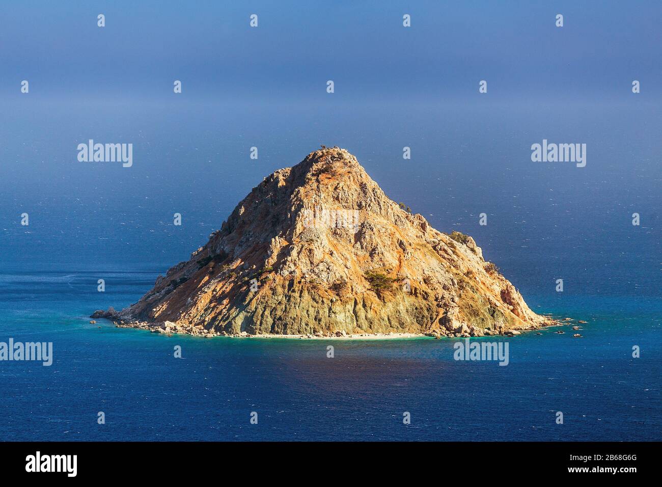 Un'isola deserta solitaria nel mare a forma di vulcano Foto Stock