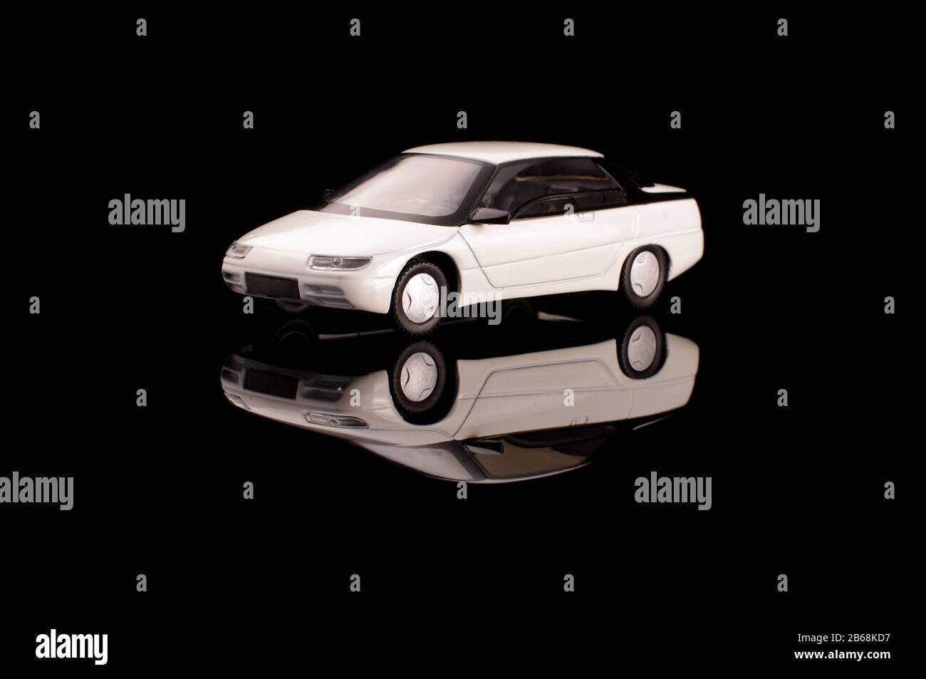 Auto modello pressofuso di colore bianco vintage sullo sfondo nero riflettente Foto Stock