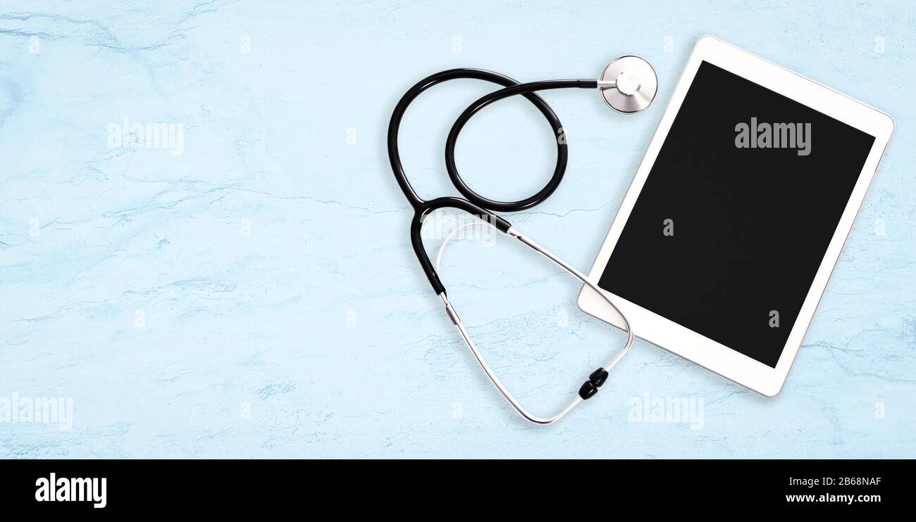 Moderno modello di trattamento medico - vista dall'alto di una compressa bianca e uno stetoscopio su uno sfondo di marmo blu con spazio di copia Foto Stock