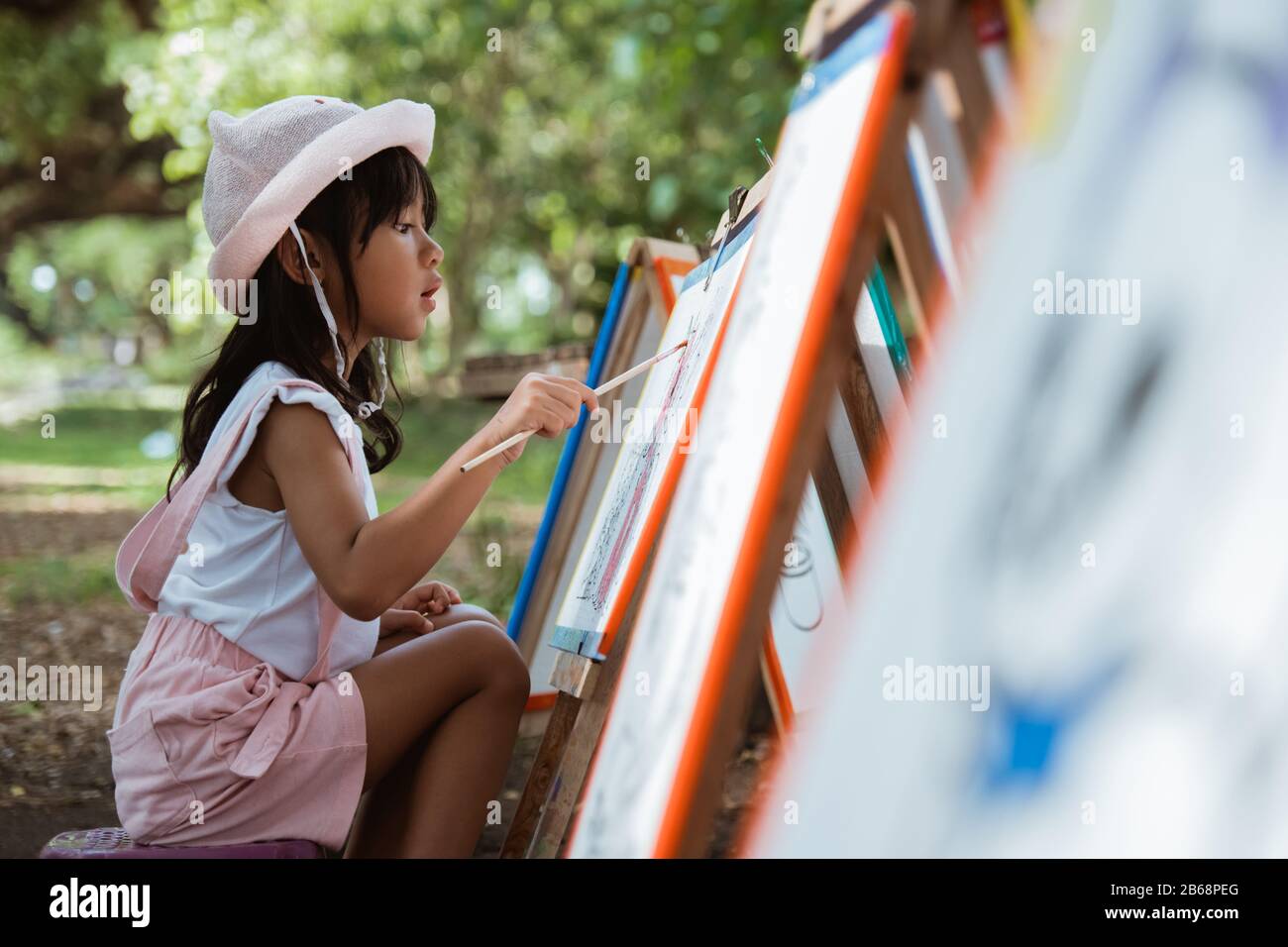 bambina che si disegna mentre in vacanza nel parco Foto Stock